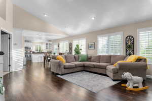 Vaulted ceilings and dark wood-finish flooring define this open-concept living space
