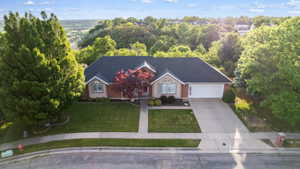 Traditional-style home featuring a dark shingle roof, light brick exterior, and an attached two-car garage