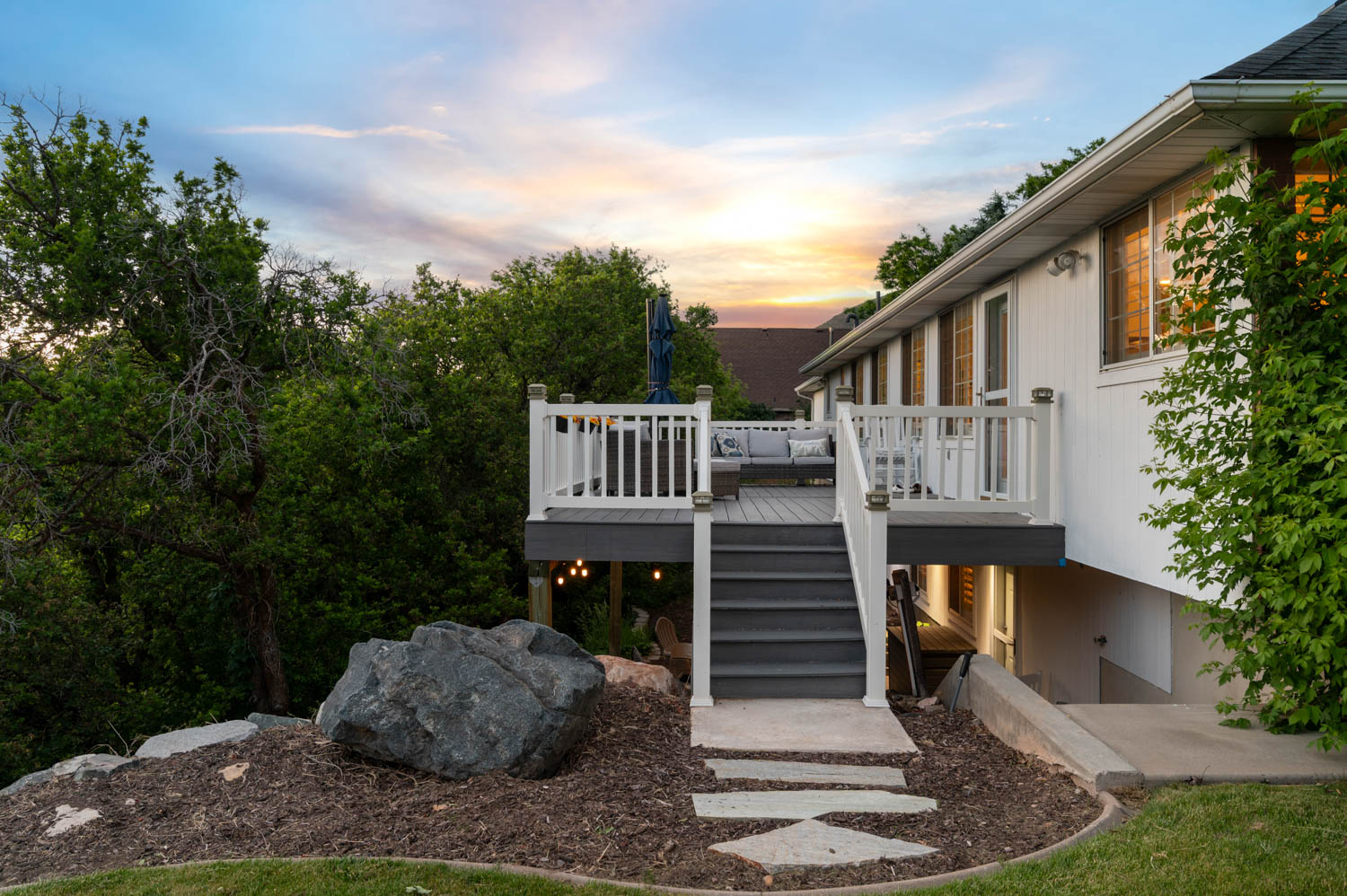 Multi-level exterior deck featuring white railings and grey composite decking