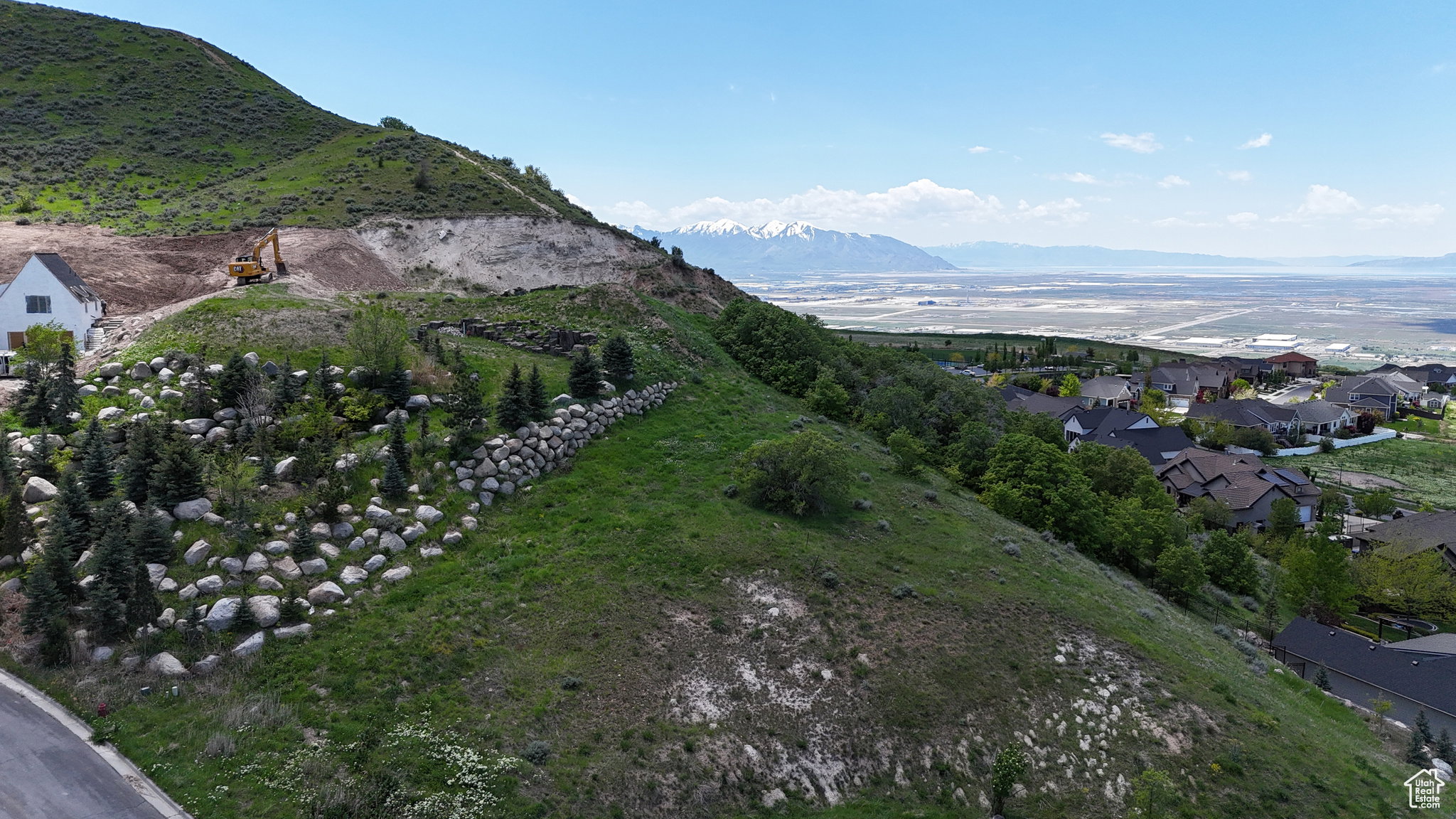 Expansive hillside property featuring established landscaping with varied rock work and mature evergreen trees