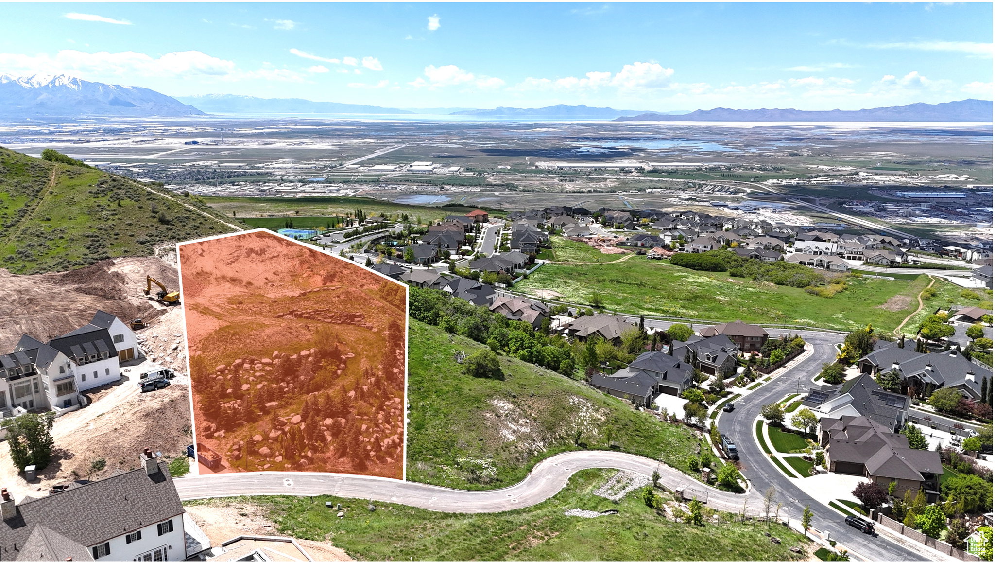 Expansive property outlined in red, featuring a mountainous backdrop and distant urban landscape