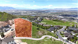 Expansive property outlined in red, featuring a mountainous backdrop and distant urban landscape