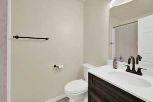 Bathroom featuring a vanity with dark wood-finish cabinetry and a white countertop, an undermount sink, and a dark bronze-finish faucet