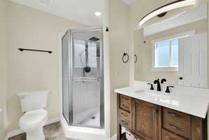 Bathroom featuring a wood-finish vanity with a white countertop, inset sink, and matte black fixtures
