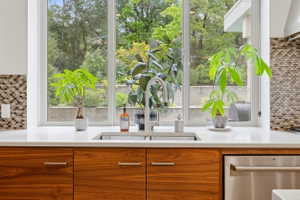 Kitchen sink with a contemporary stainless steel faucet and undermount basin, set within a white countertop