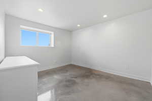 Room featuring a large window, recessed lighting, baseboard trim, and a hard-surface floor