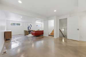 Spacious lower level featuring polished concrete flooring, recessed lighting, white trim work, and multiple windows