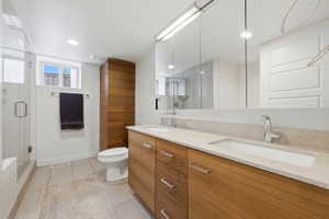 Dual vanity with integrated sinks and chrome fixtures, set against a speckled light-toned countertop