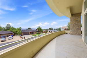 Curved balcony featuring stone veneer column, recessed lighting, and a panoramic mountain landscape
