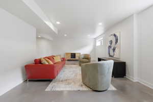 Spacious lower-level area with white walls and overhead recessed lighting