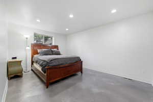 Spacious room featuring light gray flooring, white walls, and recessed lighting