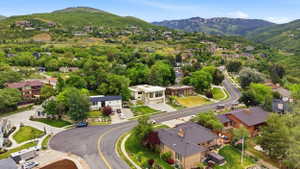 Residential area featuring winding roads, mature trees, and mountainous terrain in the background