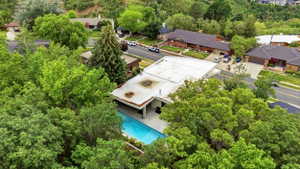 Private residence featuring a swimming pool, covered patio, and mature tree landscaping