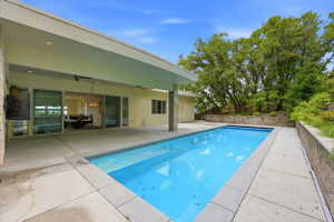 Rectangular pool with concrete surround and a covered patio area