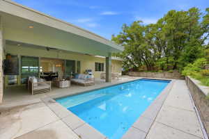 Rectangular swimming pool with integrated spa and surrounding concrete patio