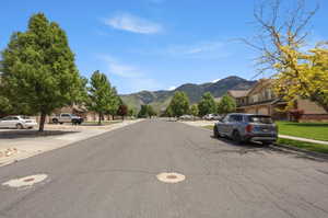 Residential street with mature trees and mountain backdrop