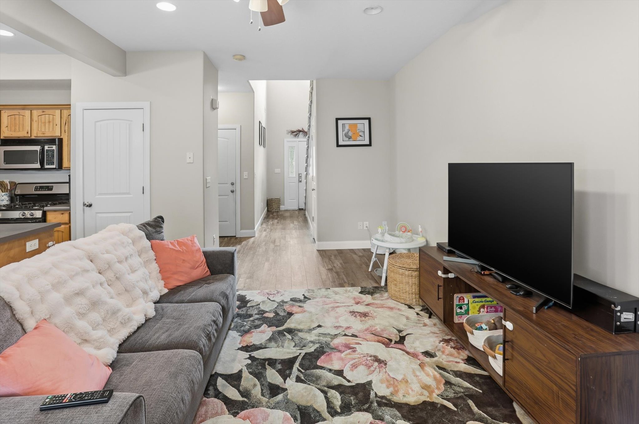 Open-concept living space featuring wood-finish flooring, recessed lighting, and a neutral wall palette