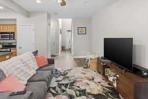 Open-concept living space featuring wood-finish flooring, recessed lighting, and a neutral wall palette