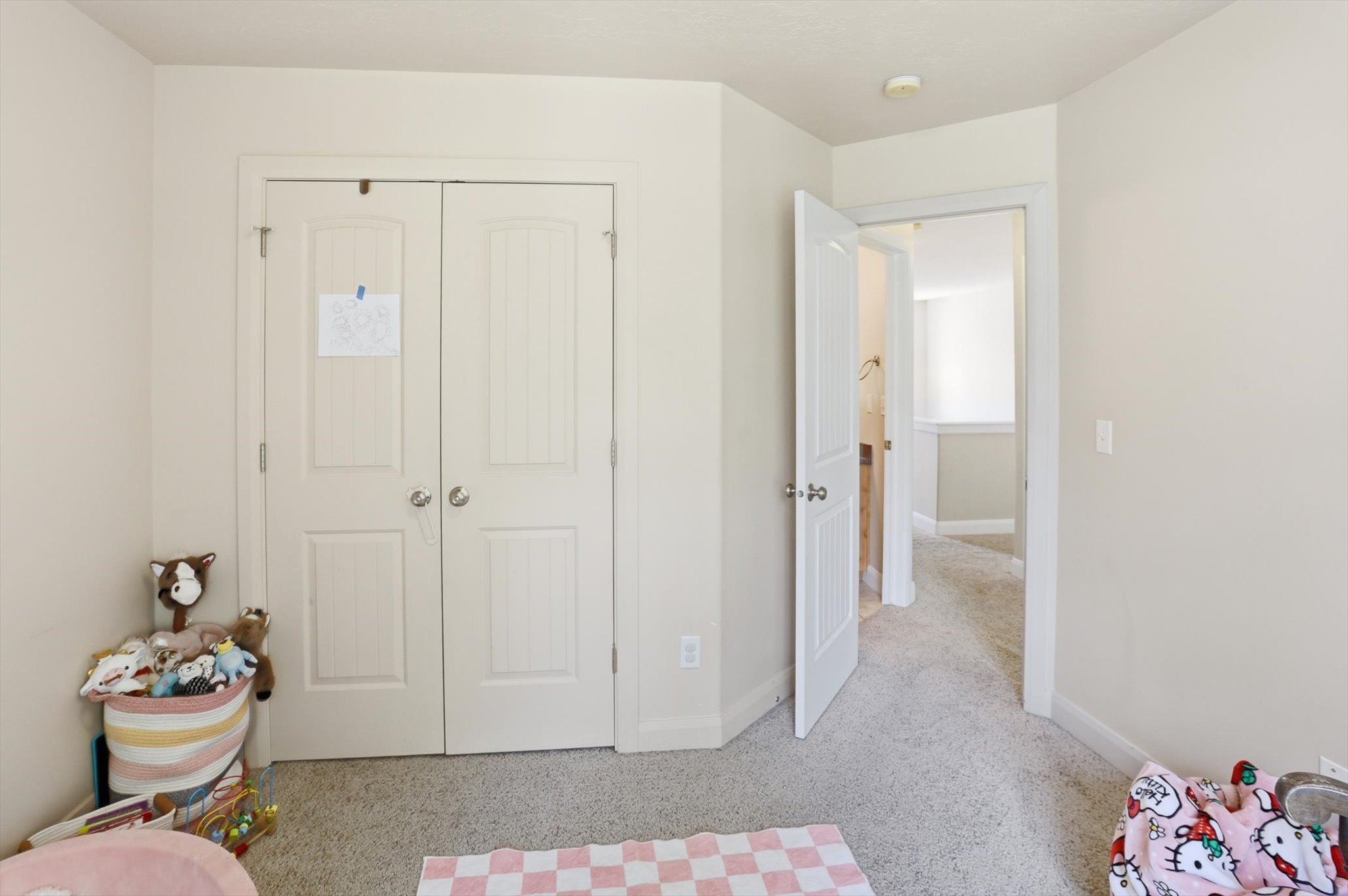 Bedroom featuring light neutral wall paint, white trim, and light-colored carpet flooring