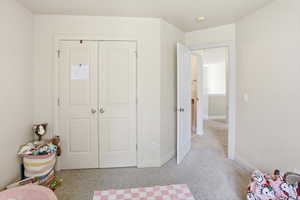 Bedroom featuring light neutral wall paint, white trim, and light-colored carpet flooring