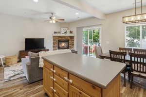 Kitchen island with light wood cabinetry and a solid surface countertop