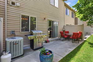 Patio area featuring a sliding glass door entry, concrete hardscaping, and a privacy fence