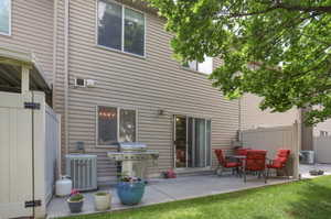 Private patio space featuring a concrete pad, sliding glass door access, and a partial privacy fence