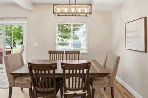 Dining area featuring wood-finish flooring, a rectangular window with blinds, and a sliding glass door leading to the exterior