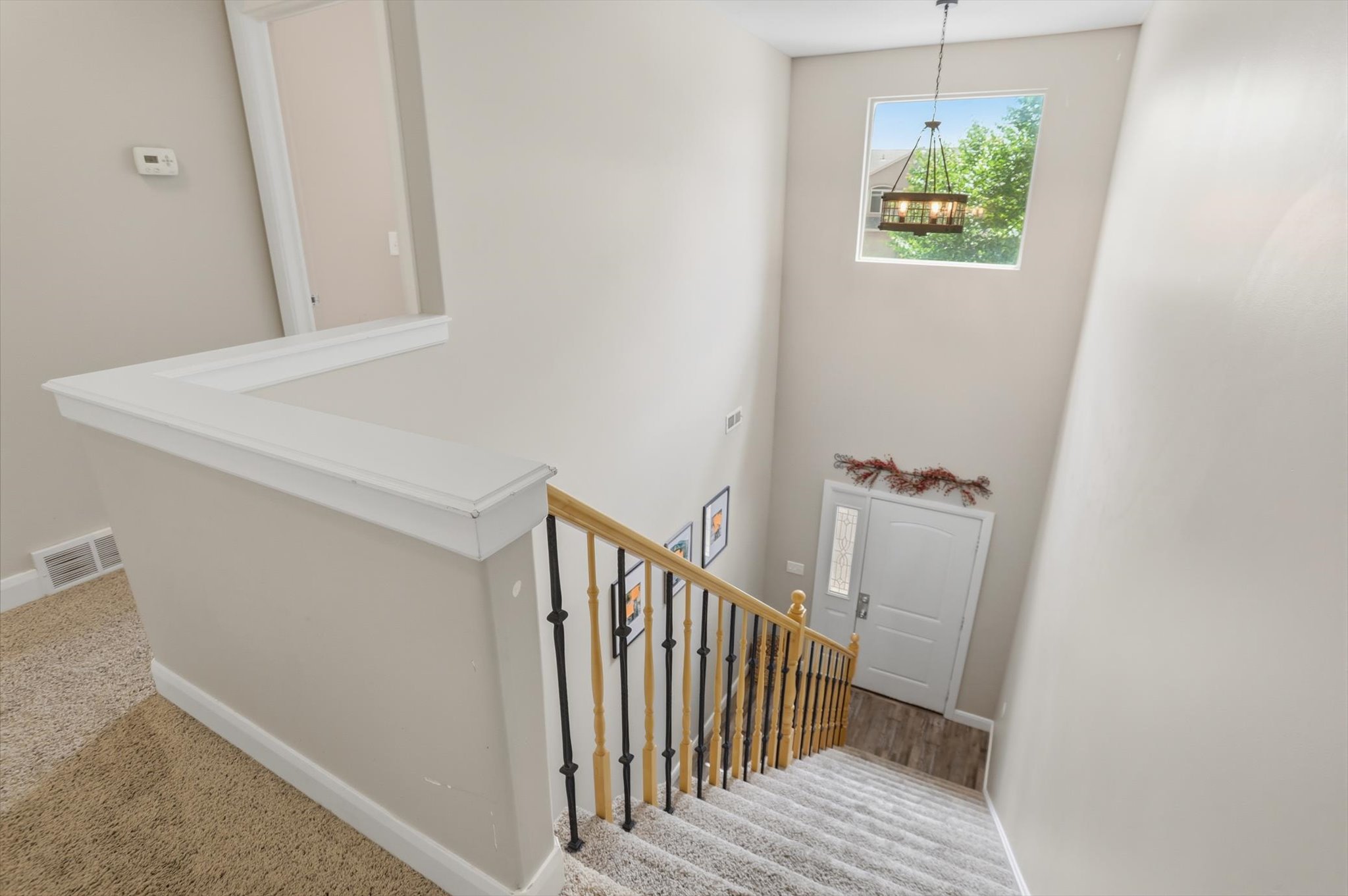 Two-story entryway with a transom window and a contemporary chandelier