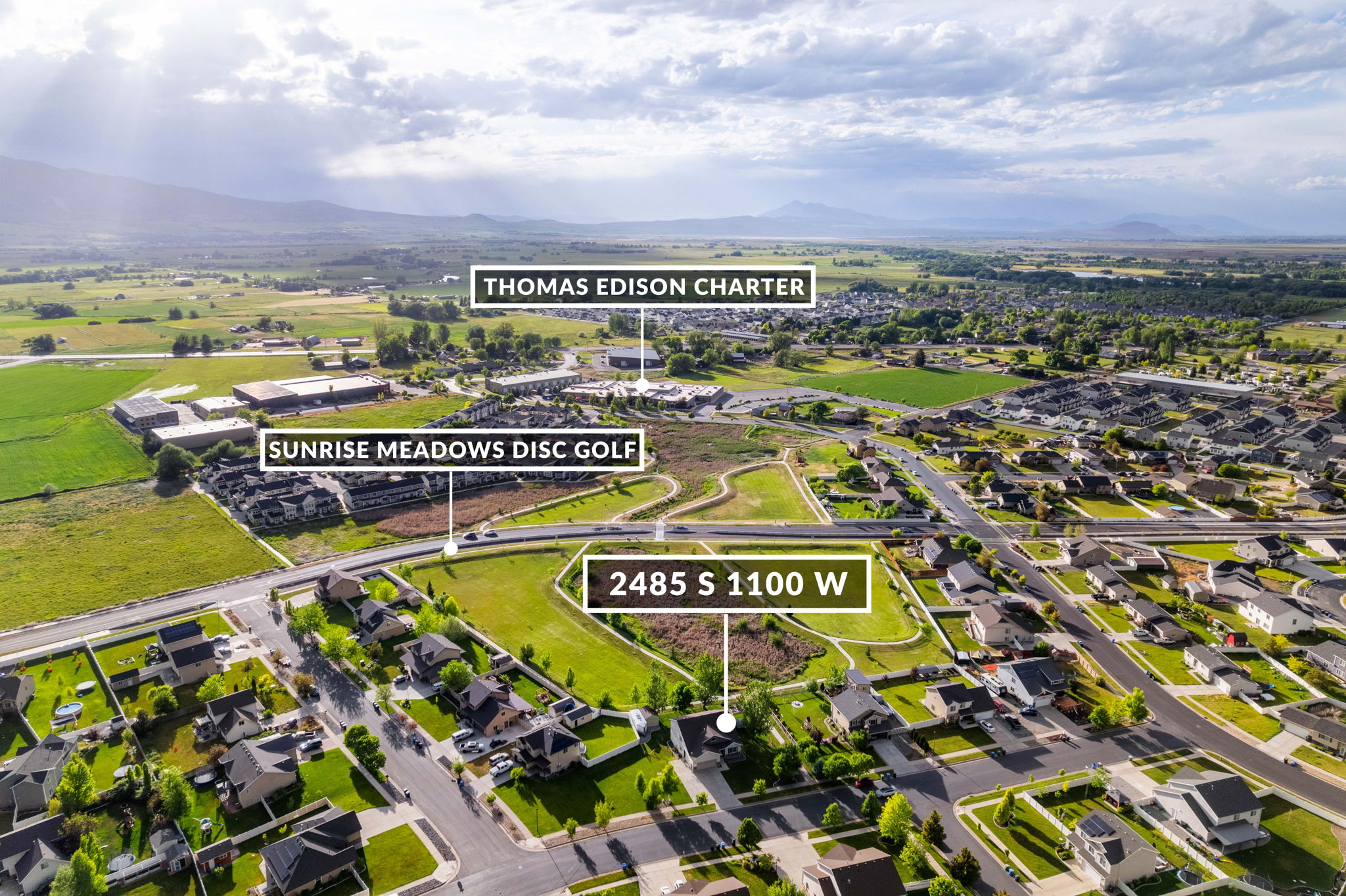 Aerial view showcasing residential areas, green spaces, and mountain backdrops