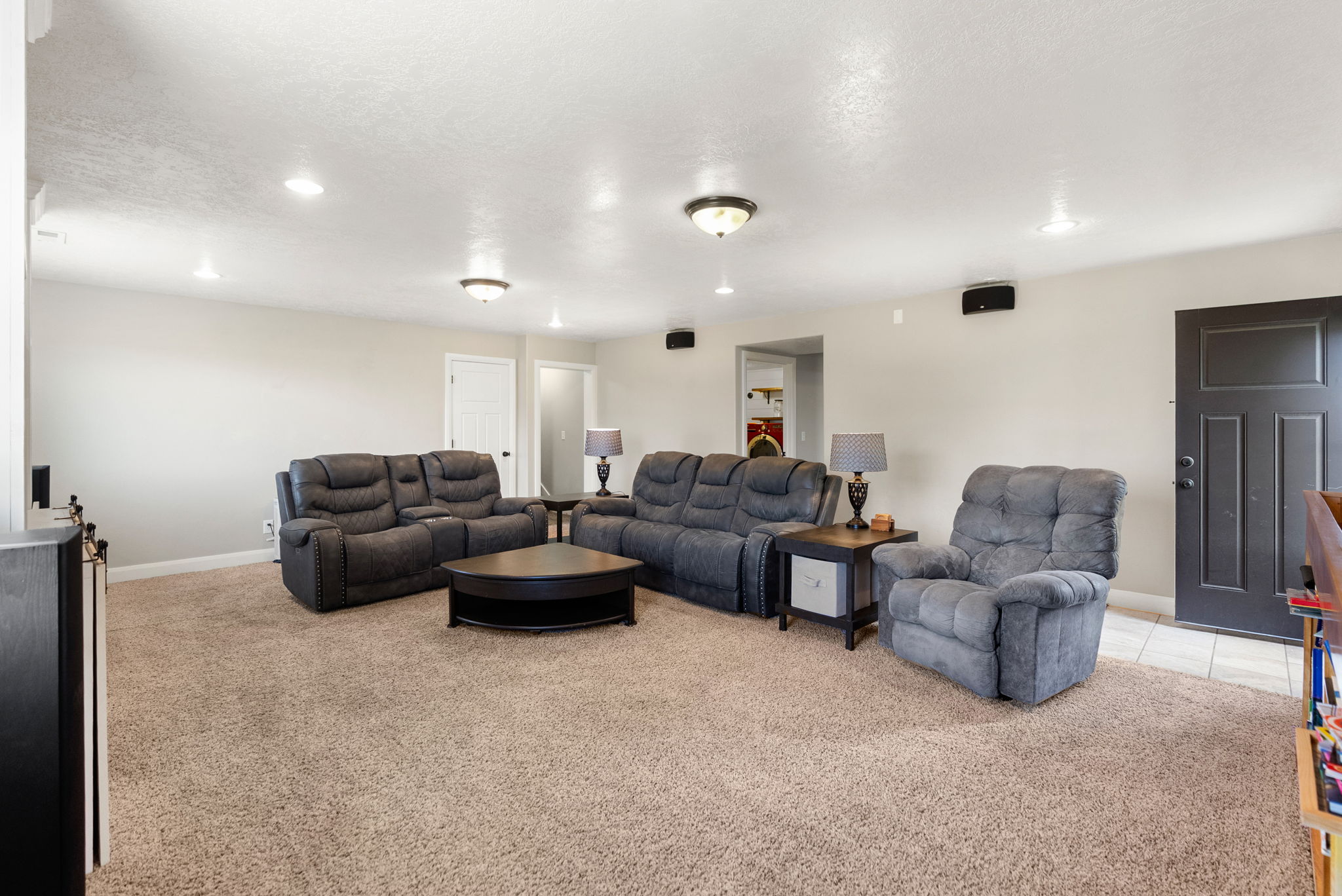 Spacious living area featuring neutral-toned carpeting, recessed lighting, and light-colored walls