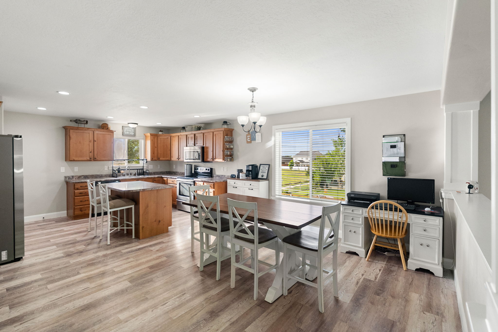 Open-concept kitchen featuring wood-finish flooring, recessed lighting, and a kitchen island with seating