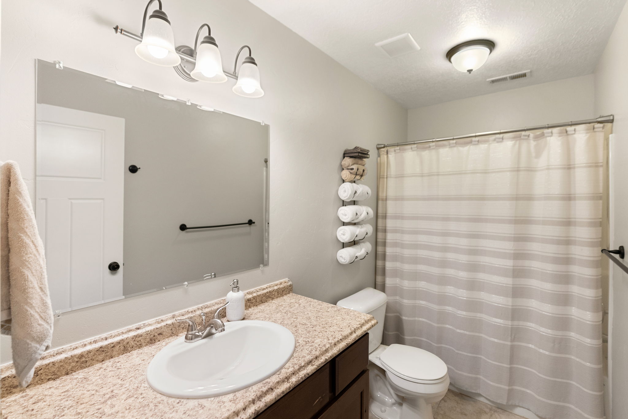 Bathroom featuring a vanity with a light-colored countertop, an undermount sink, and a chrome faucet