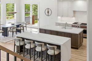 Spacious kitchen featuring two islands with waterfall countertops, and dual islands