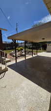 Covered patio featuring a concrete surface and supported by dark wood posts