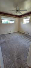 Room featuring light-toned walls, grey carpet, and a ceiling fan with integrated lighting