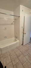Bathroom featuring a built-in tub with a shower fixture