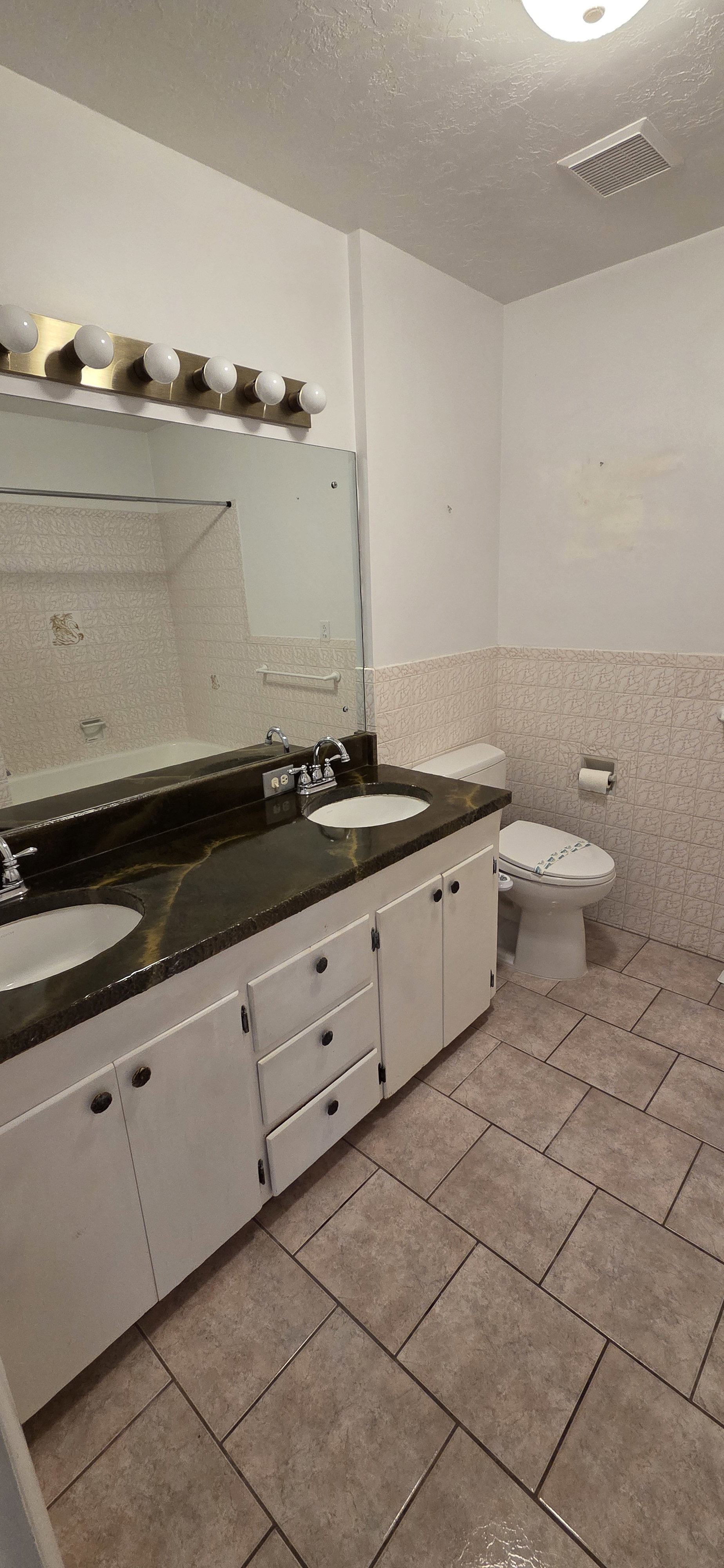 Double vanity with dual undermount sinks and a dark, veined countertop