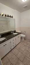 Double vanity with dual undermount sinks and a dark, veined countertop
