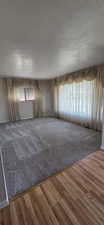 Carpeted living area with light walls and multiple windows