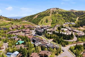 Aerial perspective highlighting a mountain community with surrounding ski slopes and lush tree coverage
