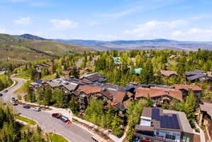 Mountainous landscape featuring residential architecture and abundant tree coverage