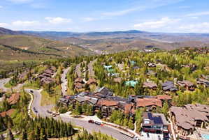 Expansive mountain landscape featuring numerous properties nestled among evergreen and deciduous trees