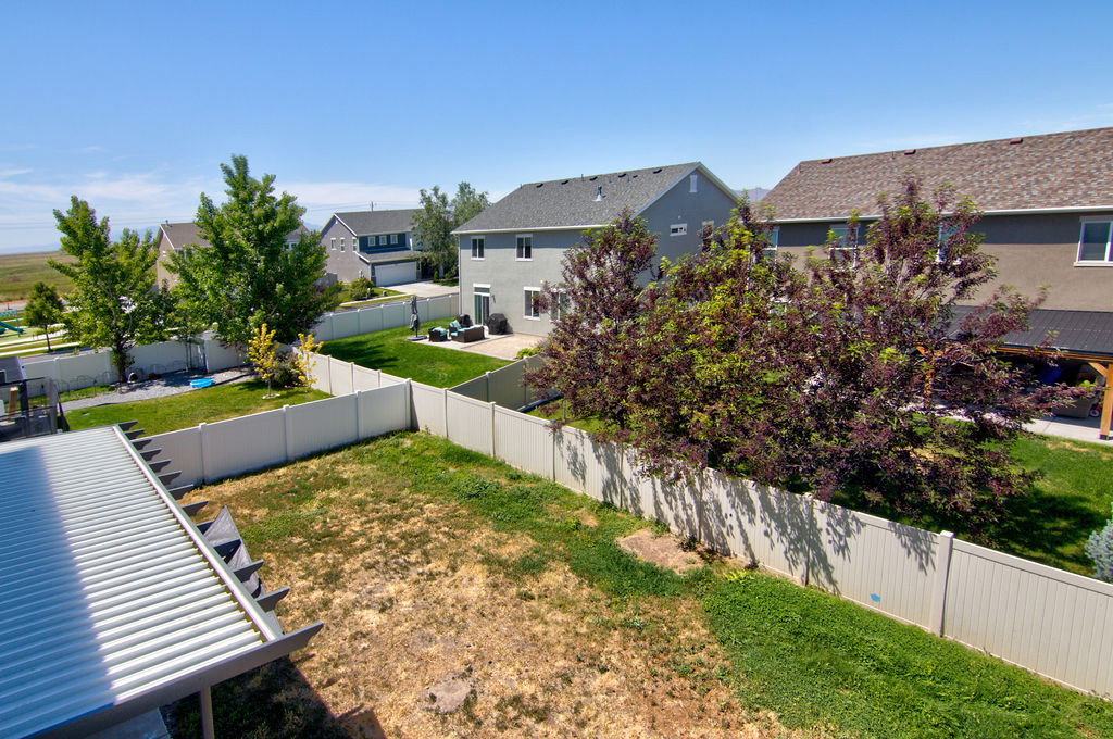 Vinyl privacy fencing enclosing a spacious backyard with mature trees and a manicured lawn
