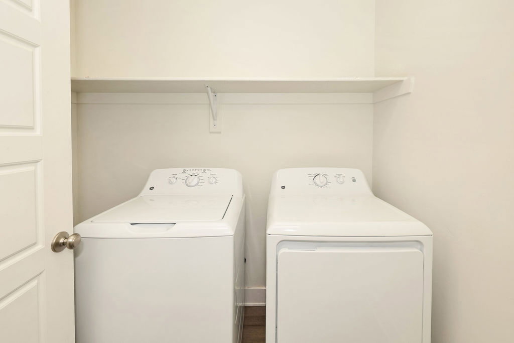 Dedicated laundry area featuring a built-in top shelf and a paneled door