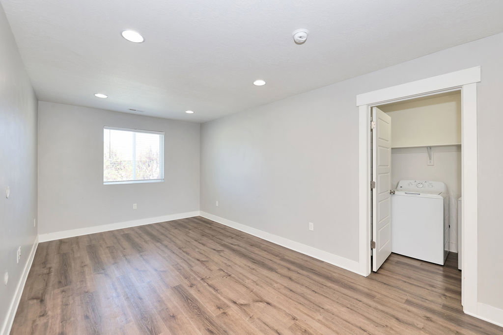 Spacious room featuring wood-finish flooring, recessed lighting, and a double-paned window