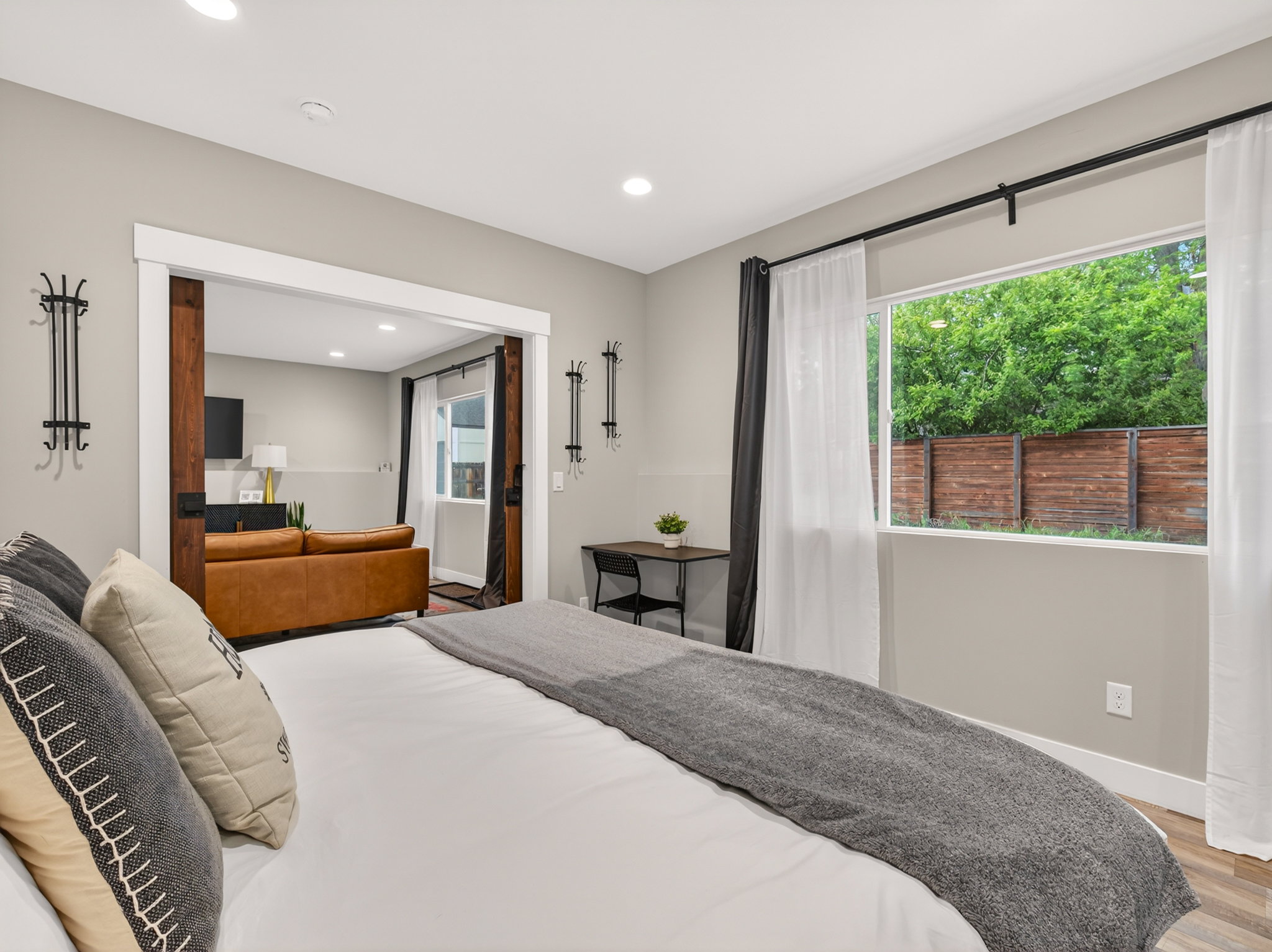 Bedroom featuring a wide window, wood-finish flooring, recessed lighting, and a barn door entry