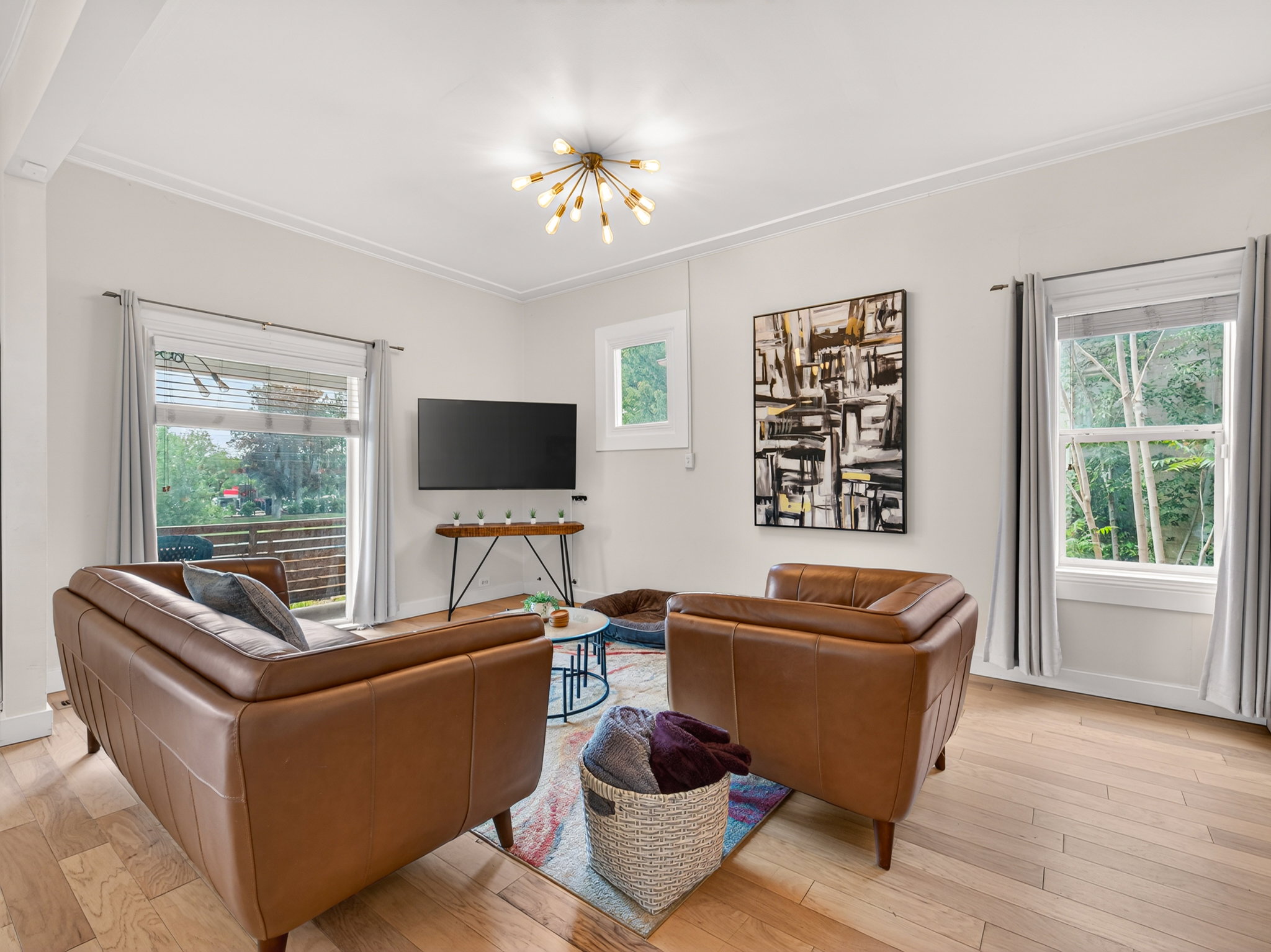 Living area with wood-finish flooring, white walls, and crown molding