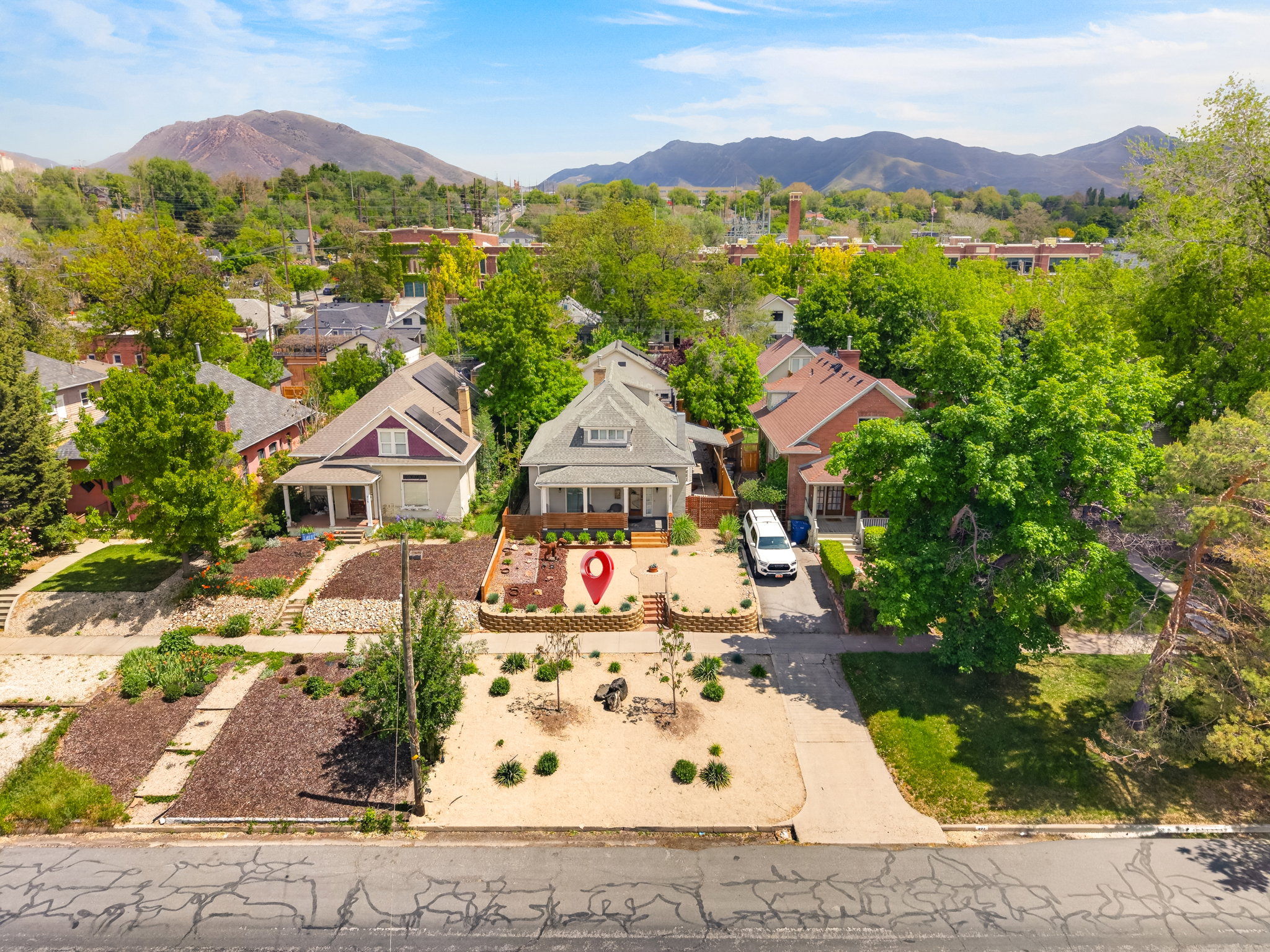 Traditional residential architecture with a covered front porch, a gravel driveway, and a terraced front yard