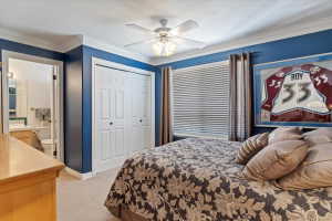 Bedroom featuring blue walls, white crown molding, and a ceiling fan with light fixture